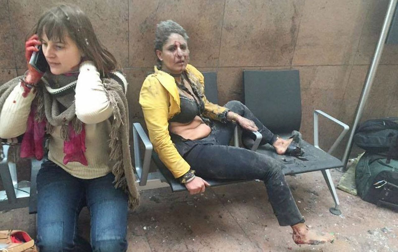 Two women sit in shock moments after a suicide bomb exploded at Zaventem airport in Brussels in March