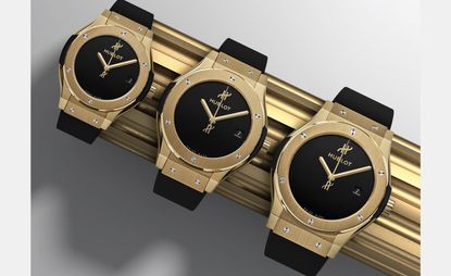 row of three black his and hers watches by hublot