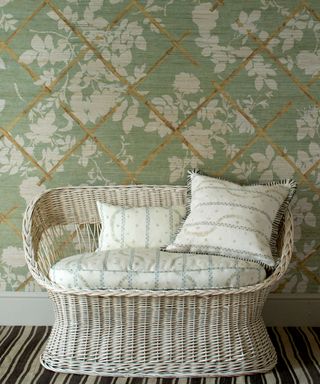 Madeaux green and white trellis design wallpaper with striped rug and white wicker sofa