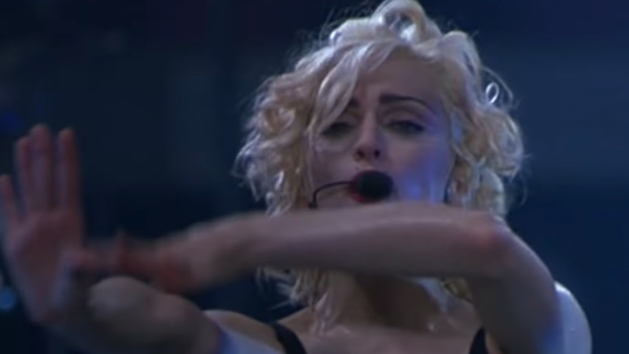 Madonna with blonde hair, singing and dancing to Vogue