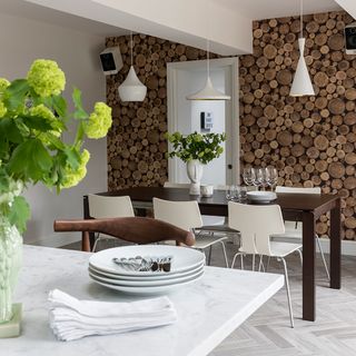 dining area with wood design wallpaper and tiles flooring and brown dining table with white chairs