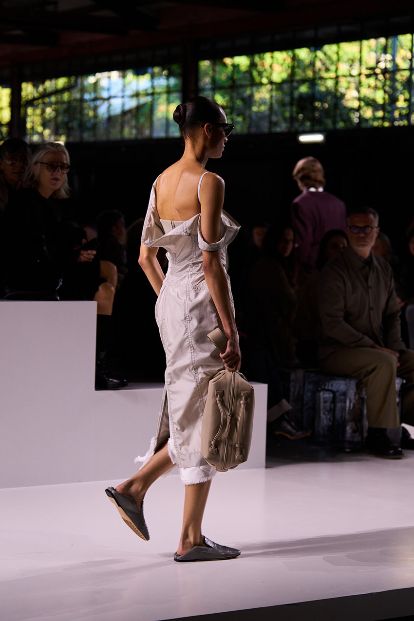 A model walking for the Bottega Veneta runway show wearing a dress and backless loafers