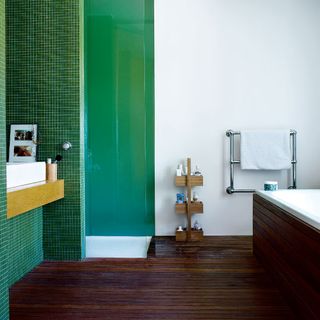 bathroom with green tiles on wall and wooden floor