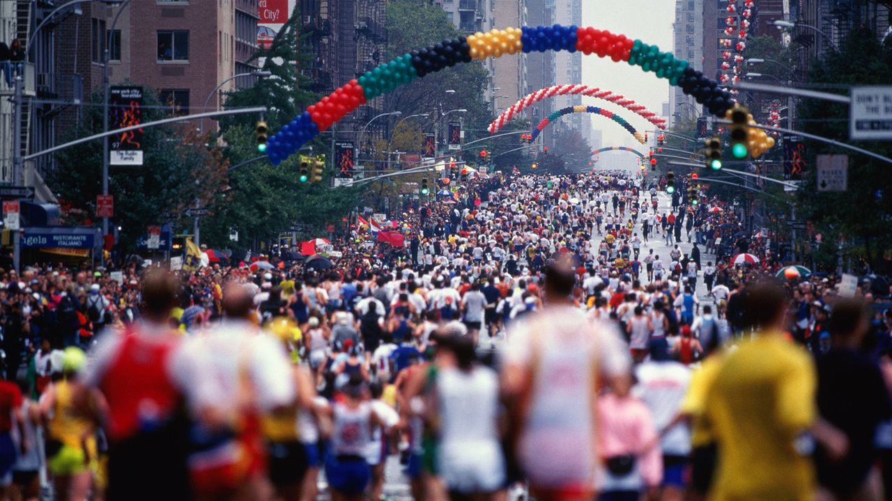 Runners on First Avenue. The New York City Marathon attracts 29,000 runners on a 26.2 mile course that begins on Staten Island at the Verrazano Narrows Toll plaza. It ends in Central Park.