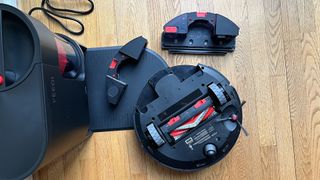 Yeedi C12 Pro Plus robot vacuum flipped upside down to show underside, along with mopping and vacuuming backplates