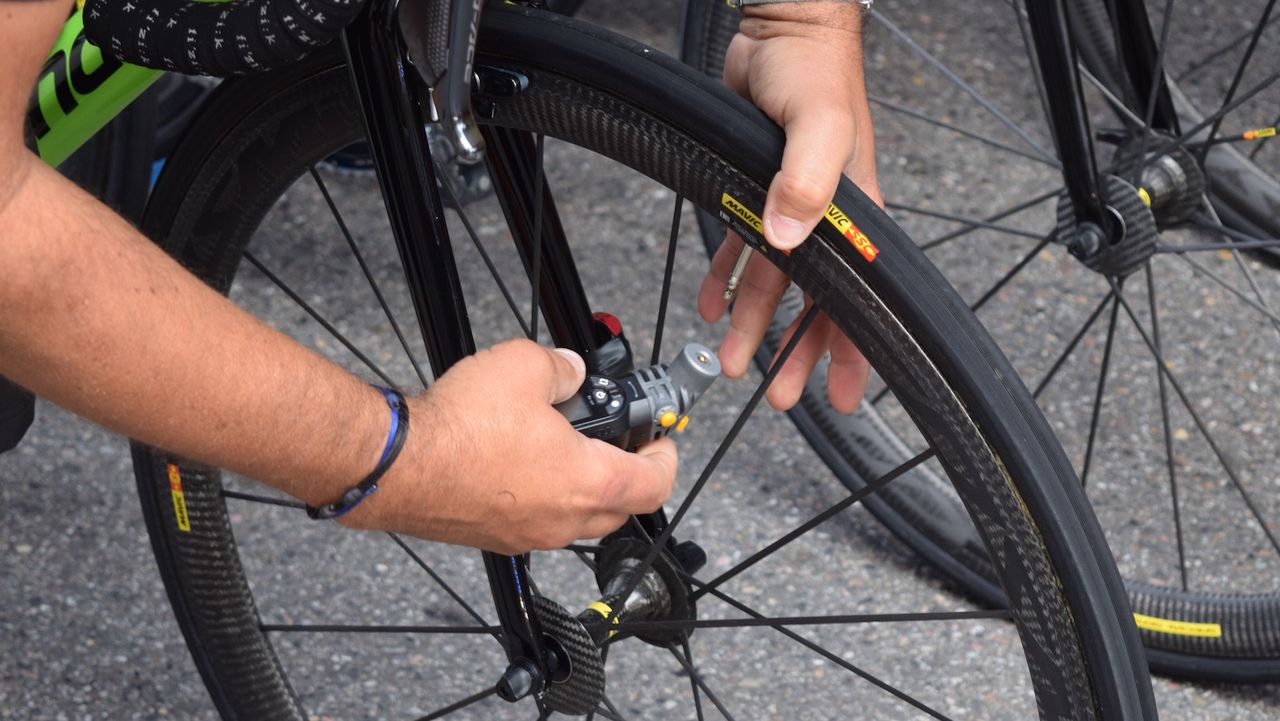 A mechanic checks Talansky's tyre pressures with a digital gauge ahead of the stage