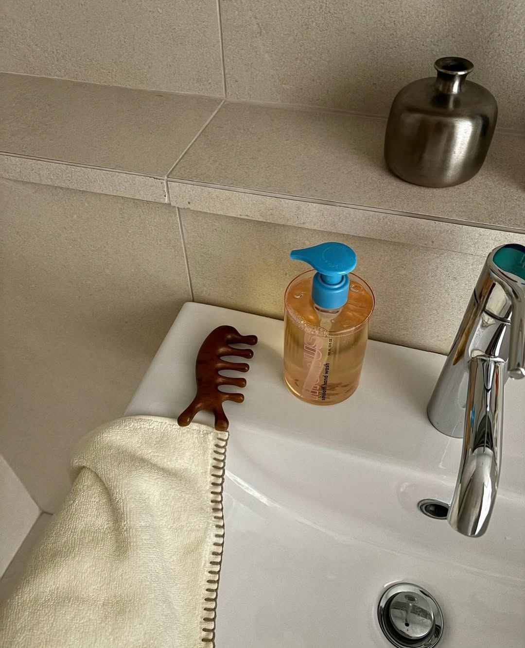 Megan Adelaide Schaefer displays a scalp tool, hand wash, and towel on her sink