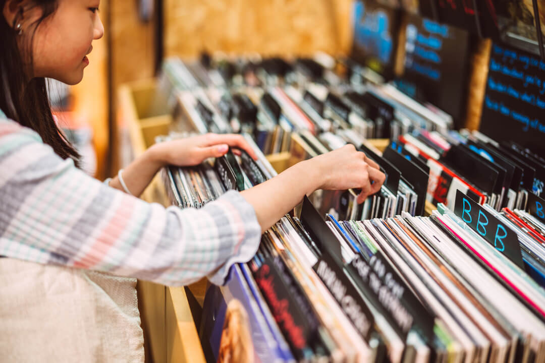 A person browsing through a collection of vinyl records in a shop