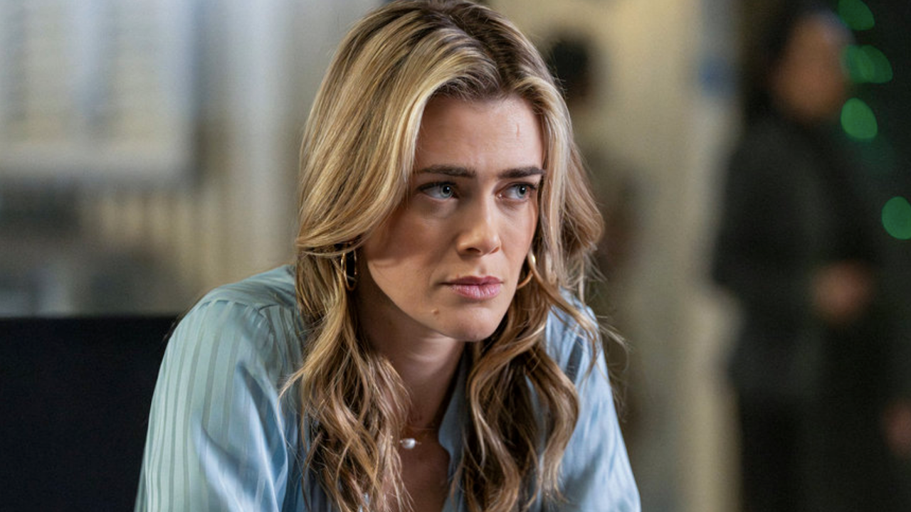 Bex wearing light blue shirt inside police station in The Hunting Party