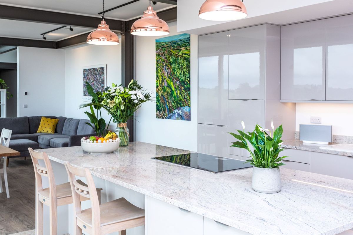The kitchen with a stone worktop in the open plan space