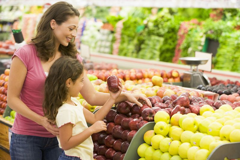 A mom shops for apples with her daughter