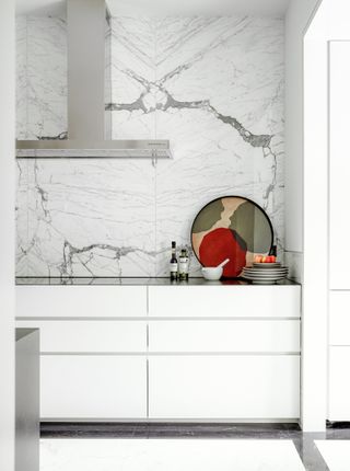 Sleek white kitchen cabinets with marble backsplash