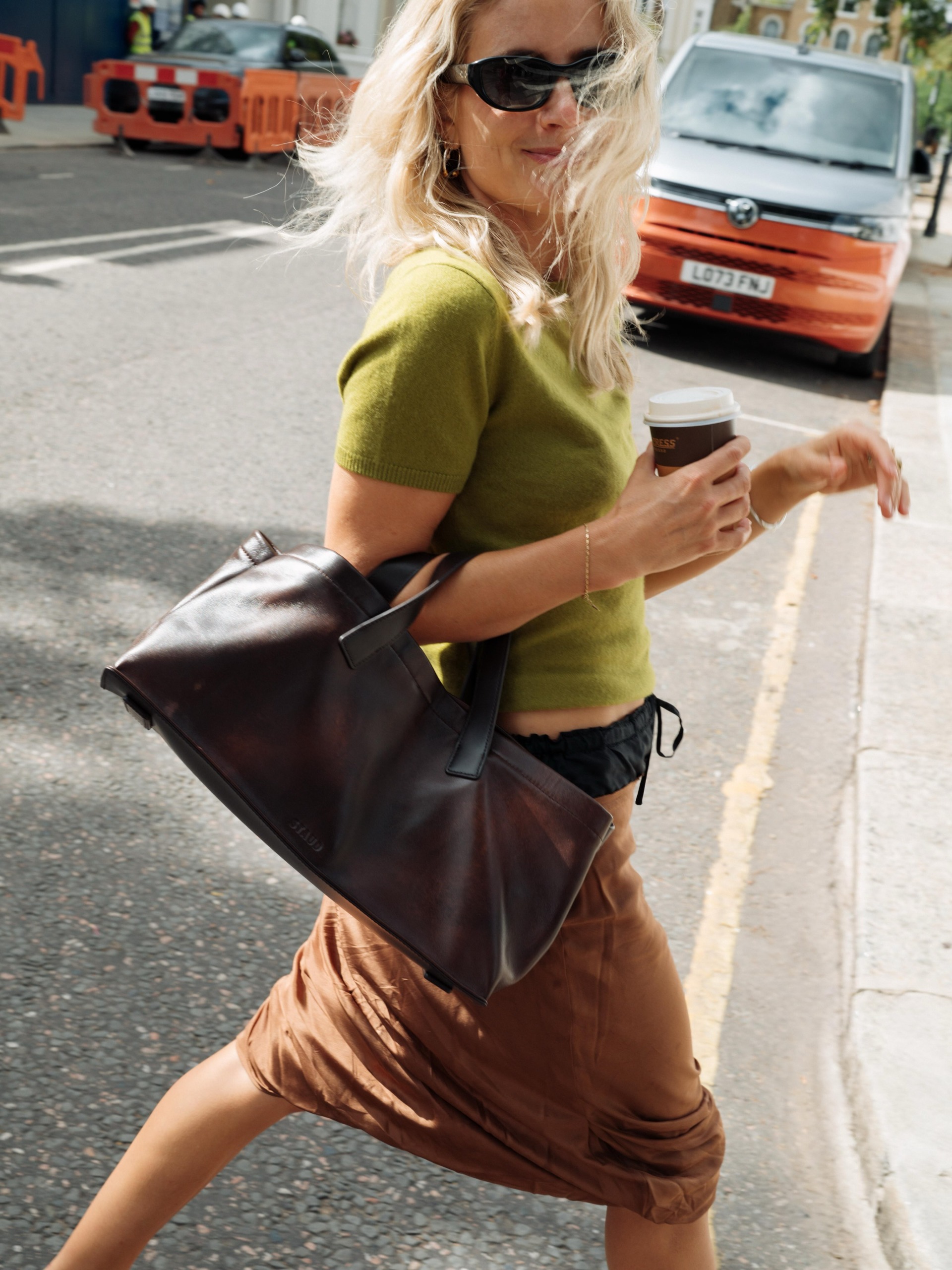colourful capsule wardrobe autumn 2026: Lucy williams. She wears a grass green top with a brown skirt, and black handbag. This image was recently taken from her Instagram.