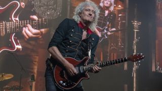 Brian May performing onstage in 2022