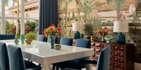 Sunny dining room featuring a tropical mural wallpaper and lacquered white dining table.