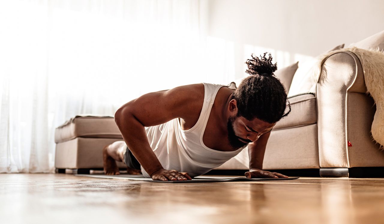 Man doing a HIIT workout in his front room