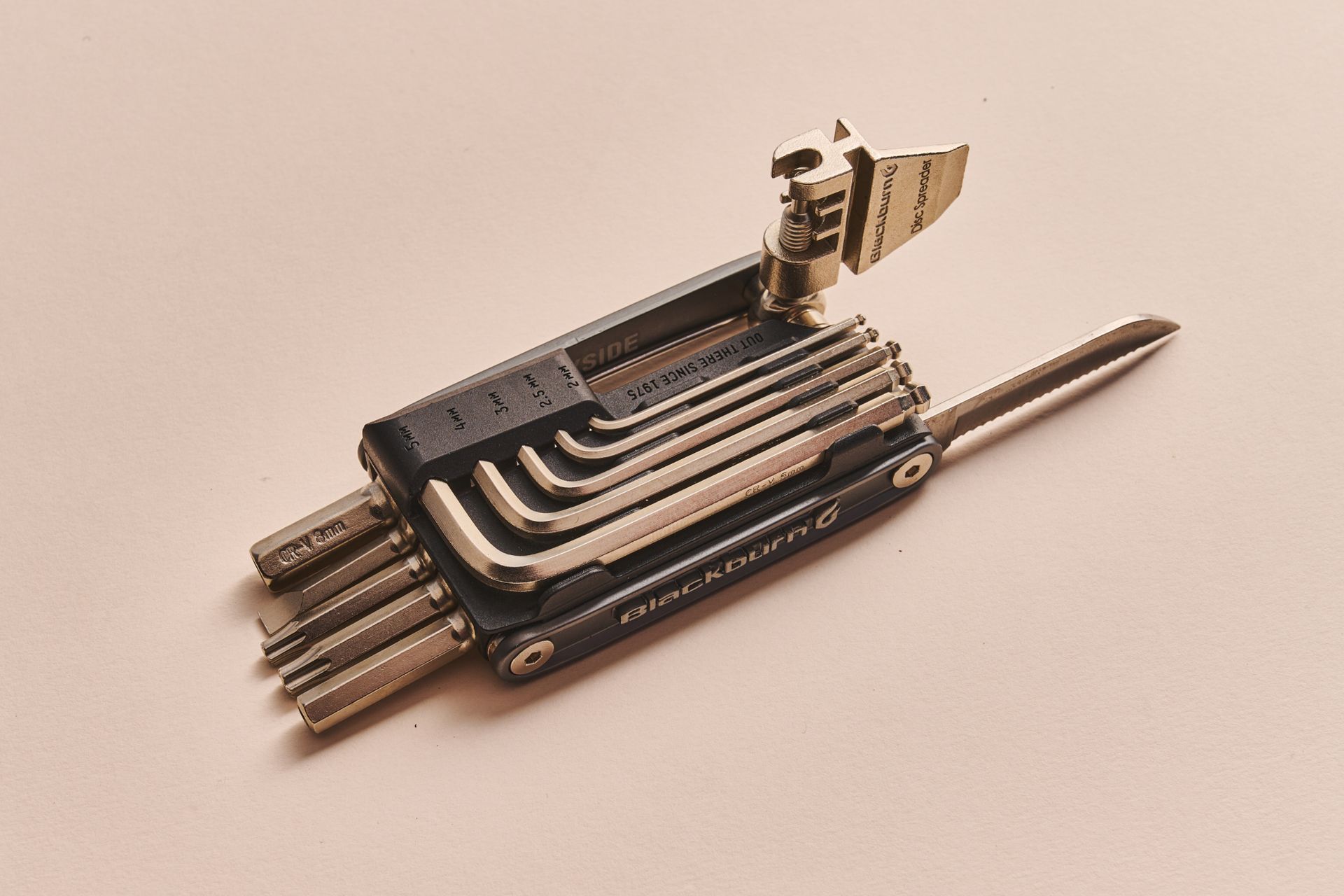 Blackburn Wayside 19 bike multi-tool including removeable allen key set and chain tool on a beige background