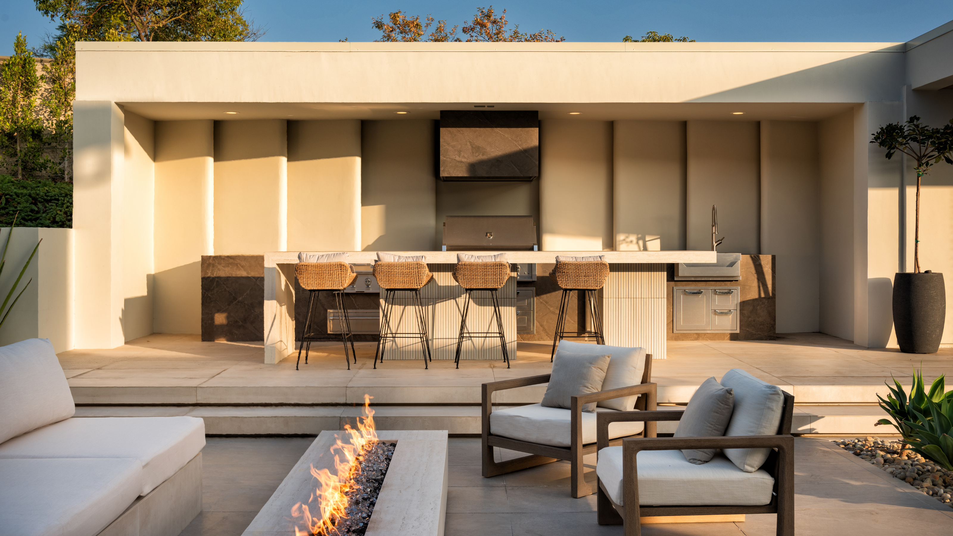 beautiful modern garden with a firepit and pergola over the bar and kitchen 