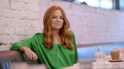 Patsy Palmer in green top sitting in london cafe 