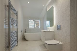 Chrome towel radiator in modern white bathroom