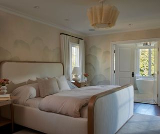 primary bedroom with blush pink walls and view to ensuite bathroom