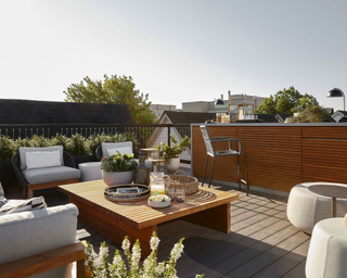 Rooftop space with planting and built-in benches and central table for seating.png