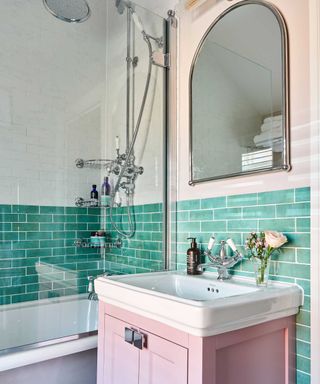 bathroom with green tiles and pink vanity