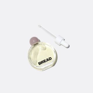 A clear round bottle of Bread Beauty Supply hair oil with a dropper top for Black-owned beauty and skincare brands.