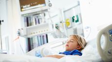 A young girl lies sleeping in a hospital bed