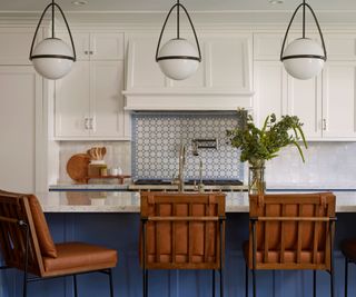 kitchen with blue island and blue patterned backsplash behind stove