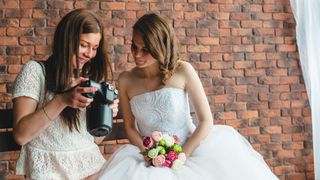 Female wedding photographer showing bride images on the back of her camera