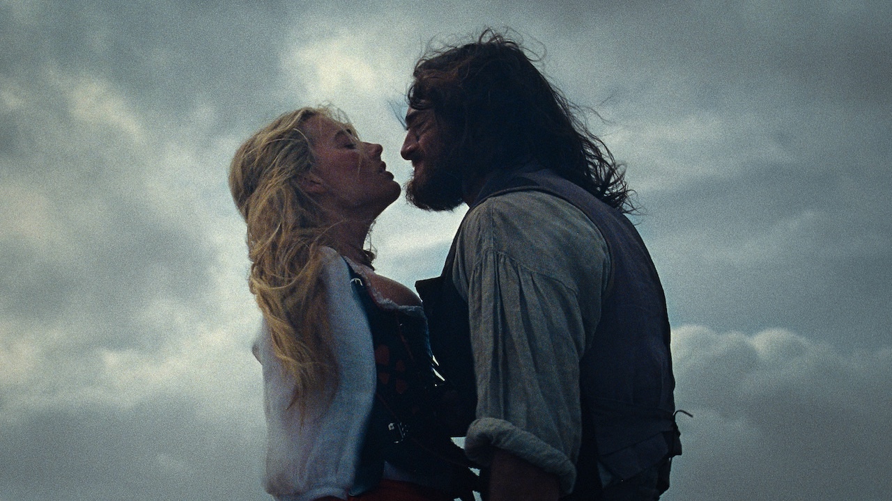 Margot Robbie and Jacob Elordi with cloudy skies behind them in Wuthering Heights