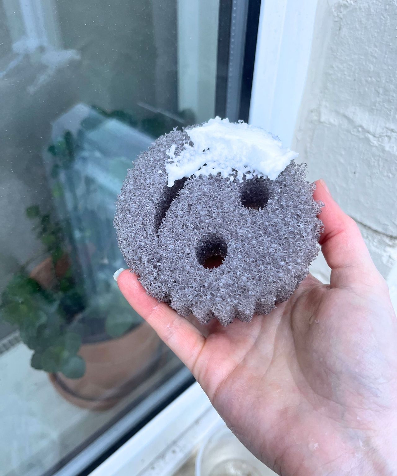 A thick white baking soda paste on a gray scrub daddy sponge