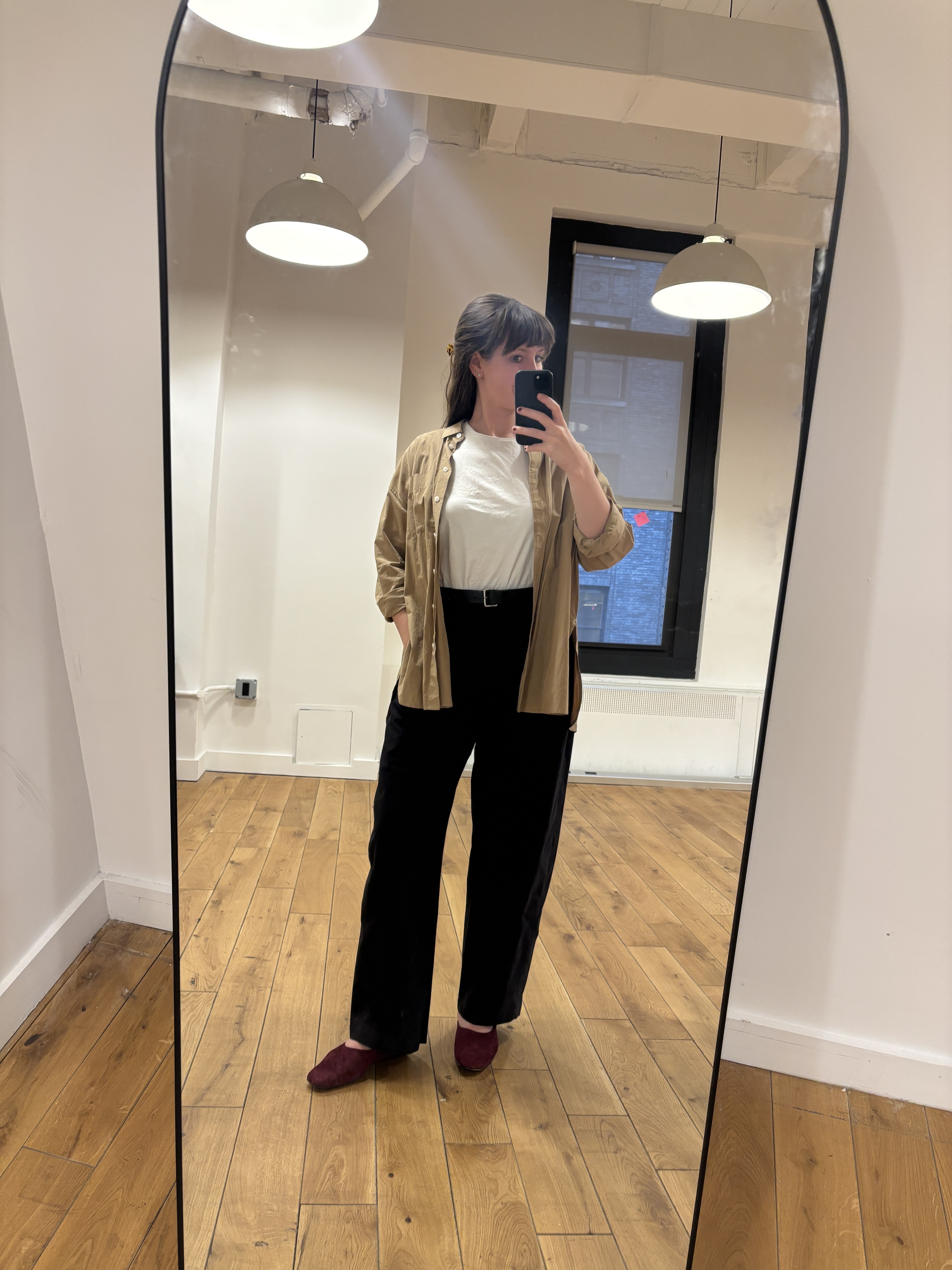 Halie LeSavage wears the Clara mules from Alex Mill x Margaux in front of a mirror at the Marie Claire office