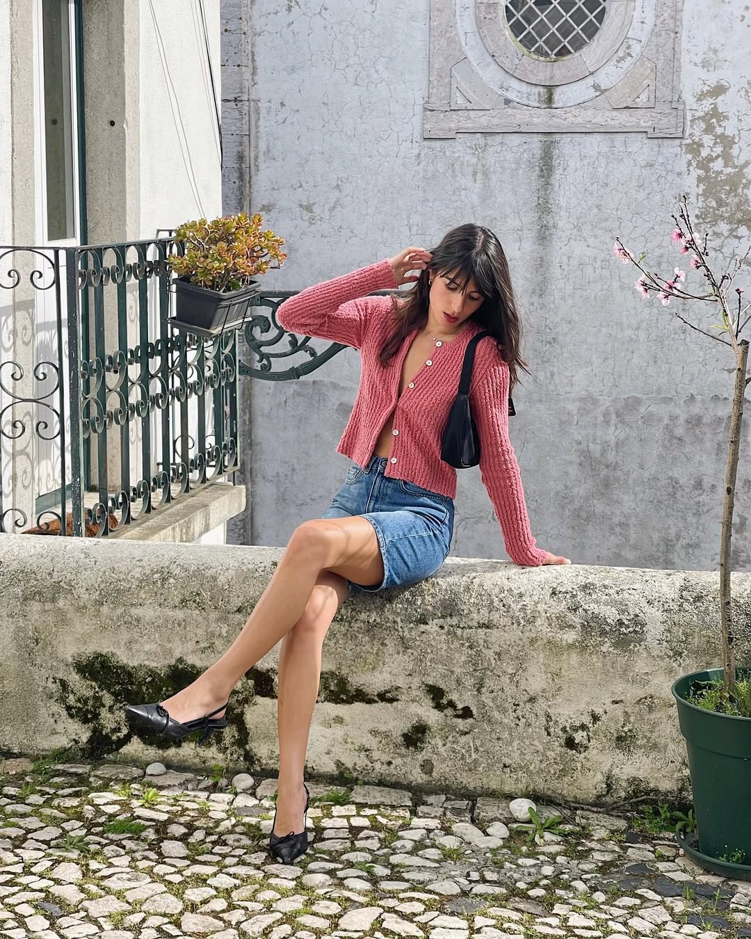 Influencer wearing denim shorts and a cardigan