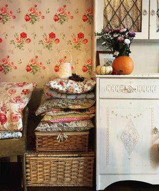 Small DIY pumpkin vase idea on top of white dresser with printed floral wallpaper backdrop