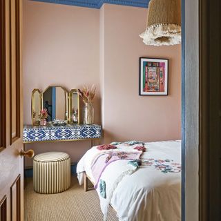 pink walled bedroom with blue and white dressing table