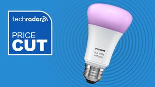 Philips Hue light bulb on blue background with white text reading 'TechRadar price cut'