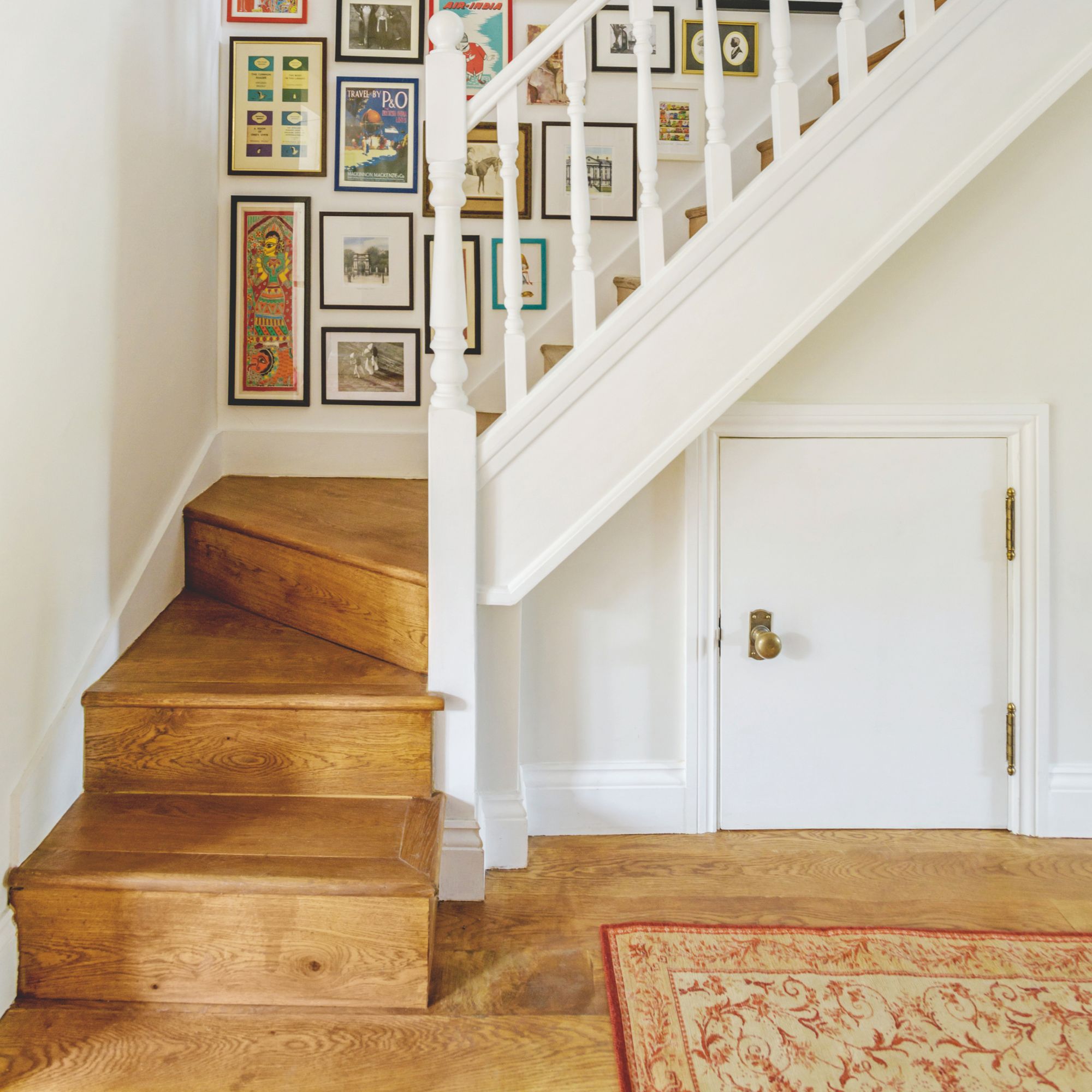 Hallway and staircase with wooden flooring, and a gallery wall going up the stairs