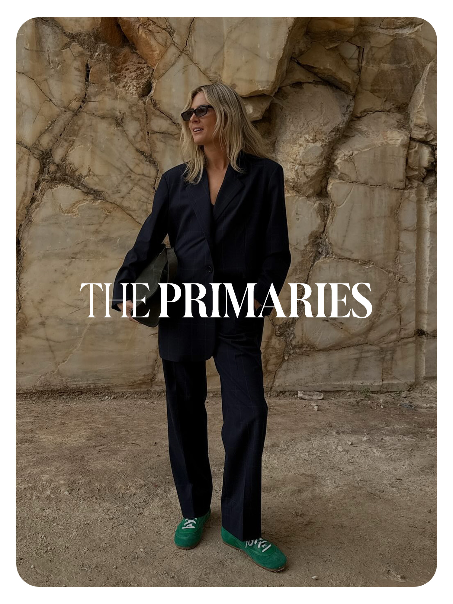 Lucy Williams at the COS S/S 25 show in Greece wearing a navy blue suit and green sneakers. Text reads, &quot;The Primaries.&quot;