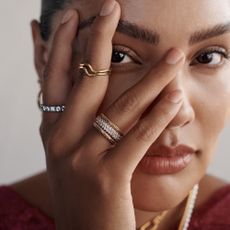 Model wearing Pandora rings with hand on face