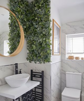 white bathroom with large panel of greenery on wall