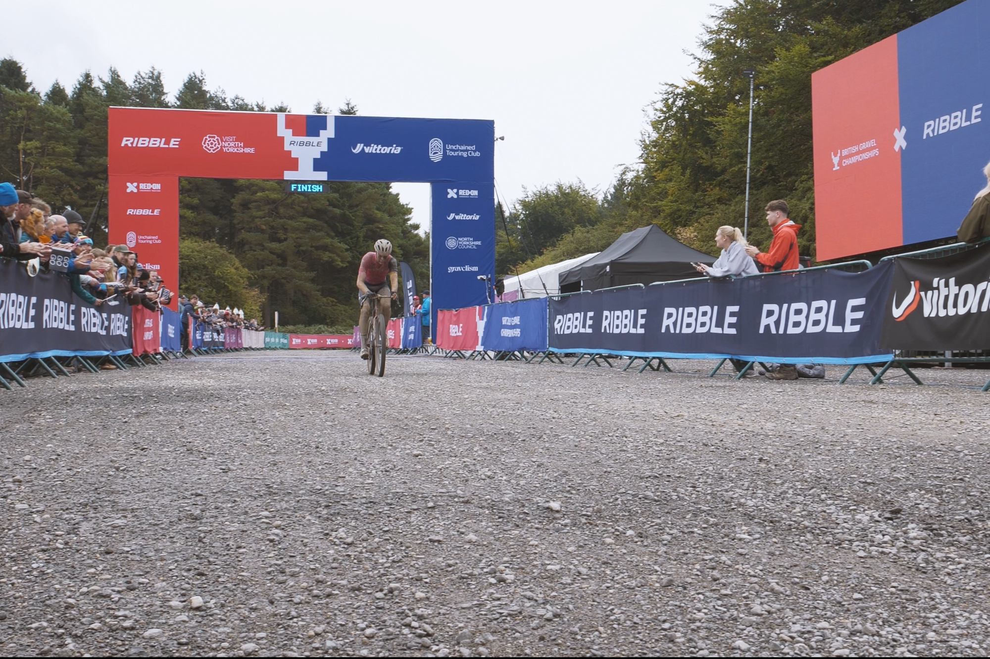 A pink and purple Ribble gravel bike being used by both male and female athletes on a misty day at British Gravel Champs