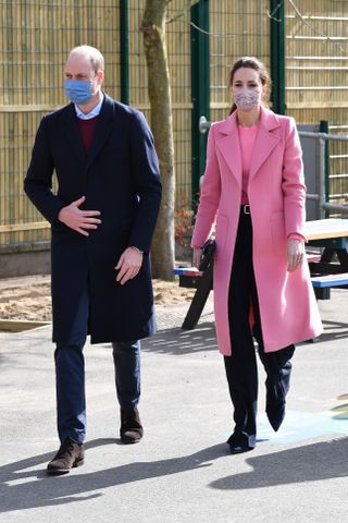 Kate Middleton wearing pink boden sweater with Prince William by her side walking