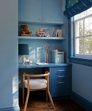 A two-toned blue kid's room with a built-in desk