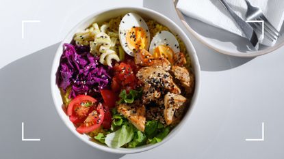 Bowl of protein-rich foods, including eggs and edamame, representing what happens if you eat too much protein