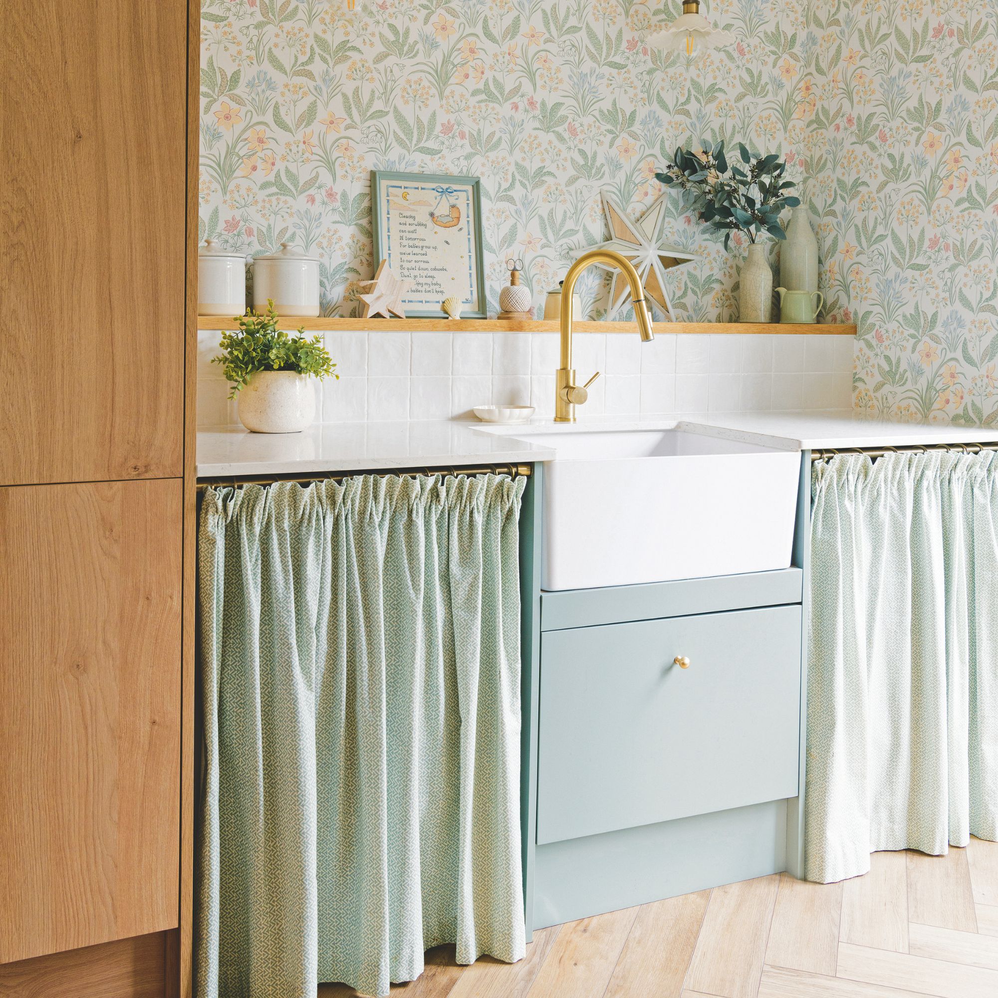 utility room with white worktop and sink, with light blue cabinets and cafe curtains over them
