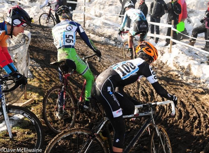 Junior men rounding a tight muddy turn