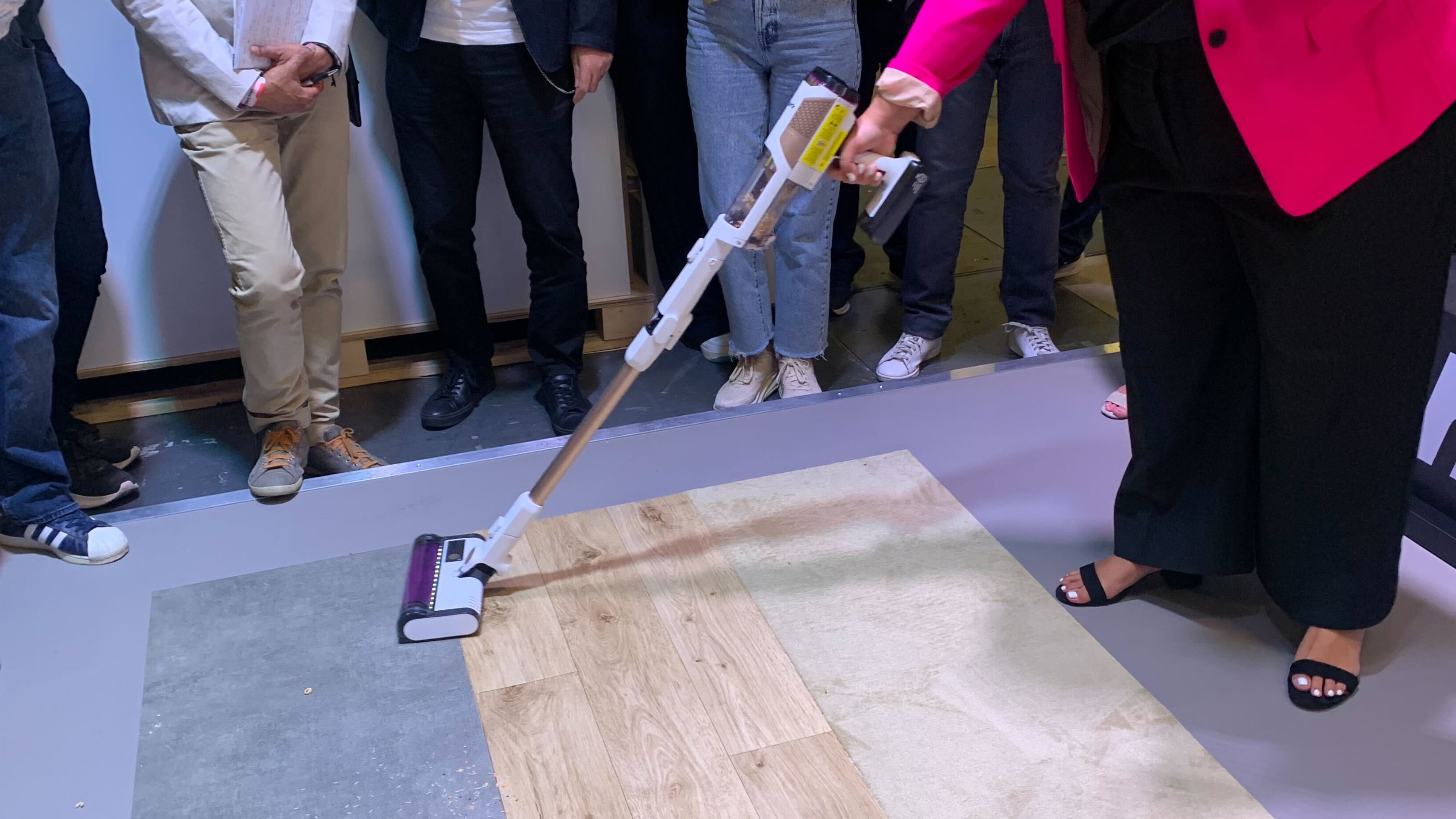 A woman using a SharkNinja vacuum at the IFA trade show