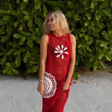 a woman wearing a red crotchet beach dress